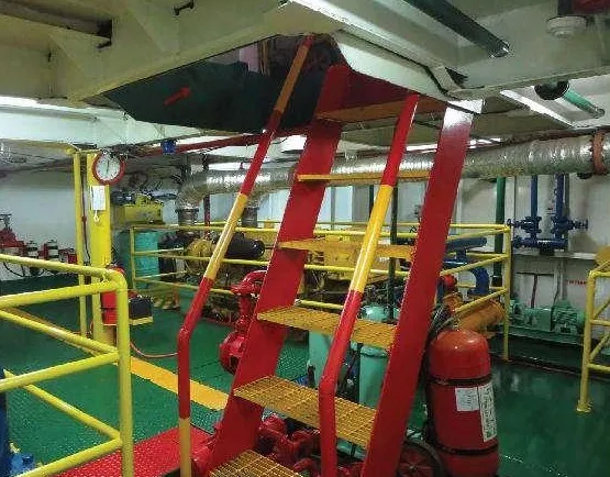 Engine room of a THS vessel with a red ladder, yellow safety railings, and a fire extinguisher