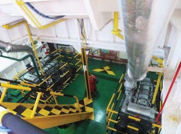 Engine room of a THS vessel seen from above, with two main engines and yellow-railed walkways